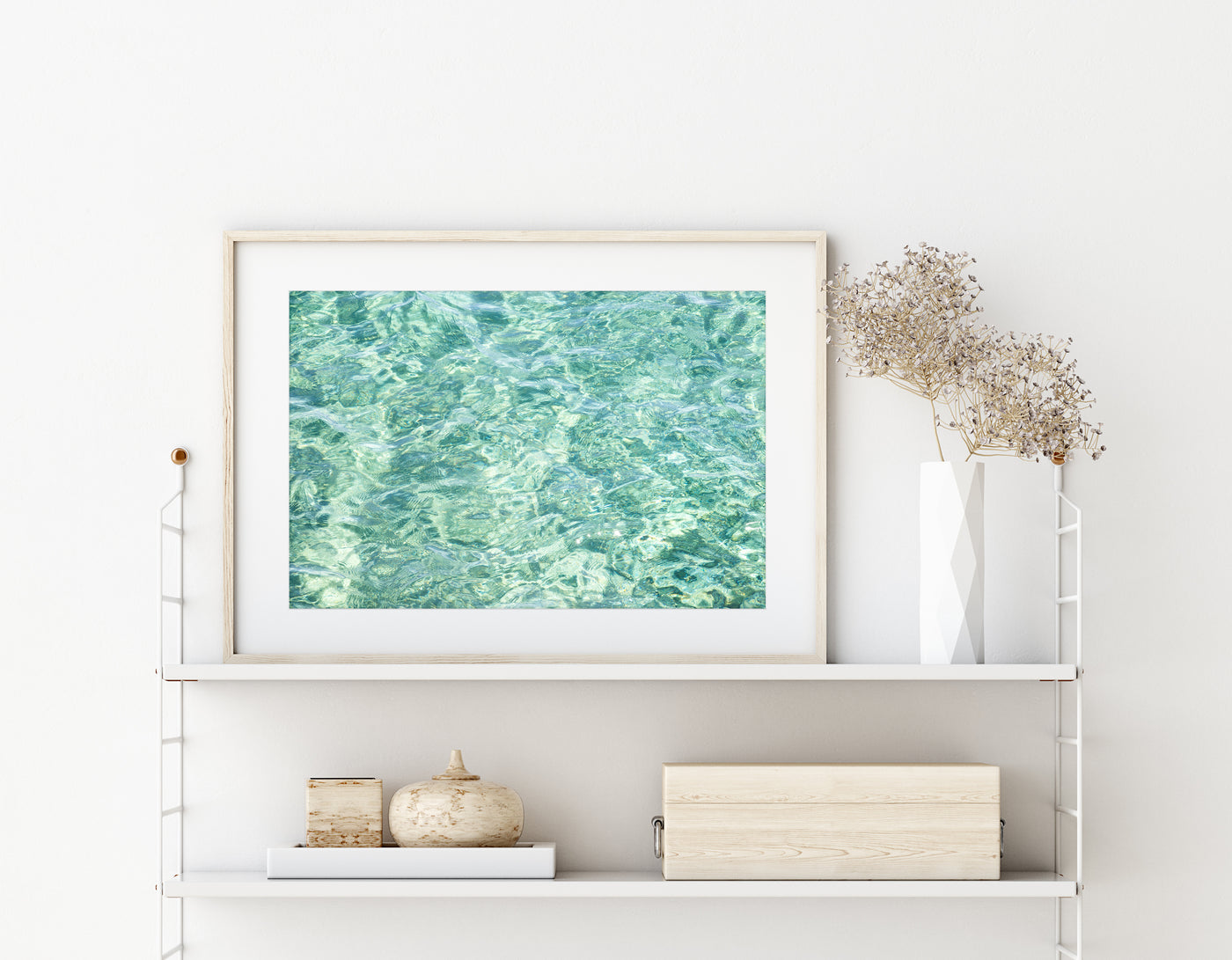 Framed green abstract art print by Cattie Coyle Photography on string shelf with neutral colored decor items