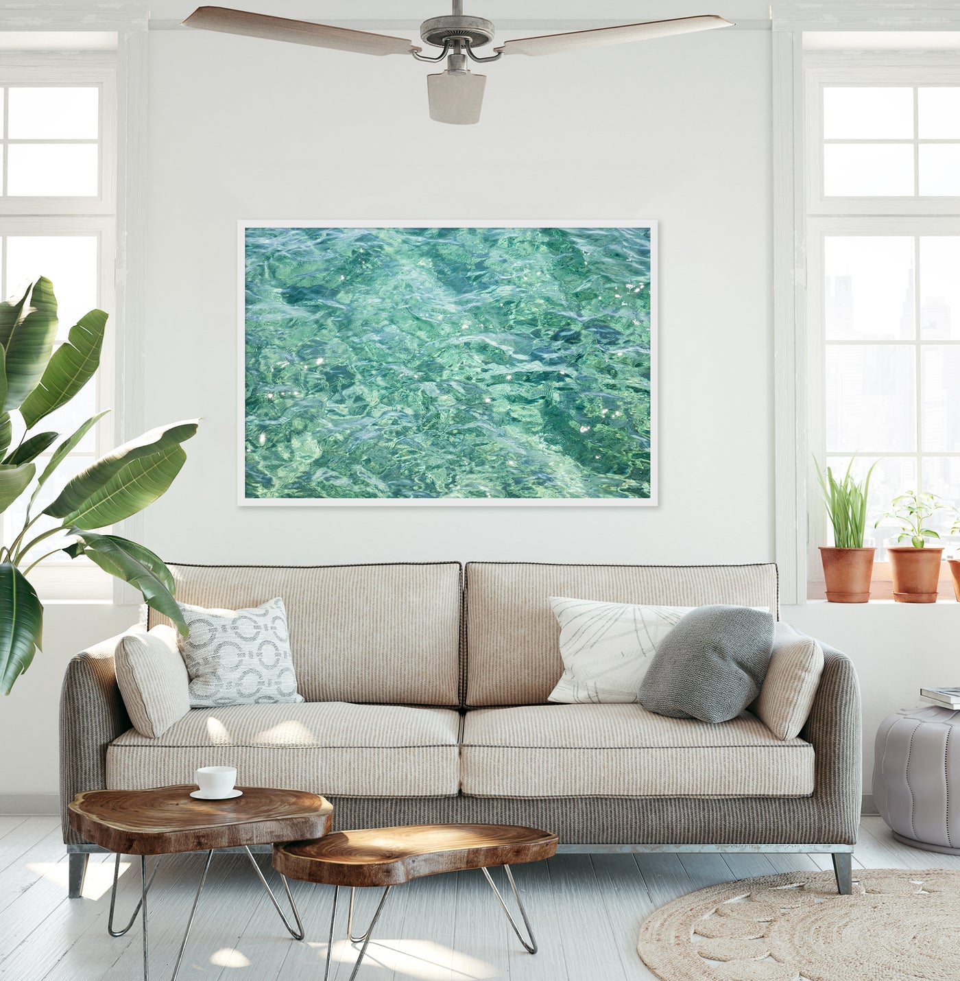 Large framed water abstract art print above couch in modern beach house living room